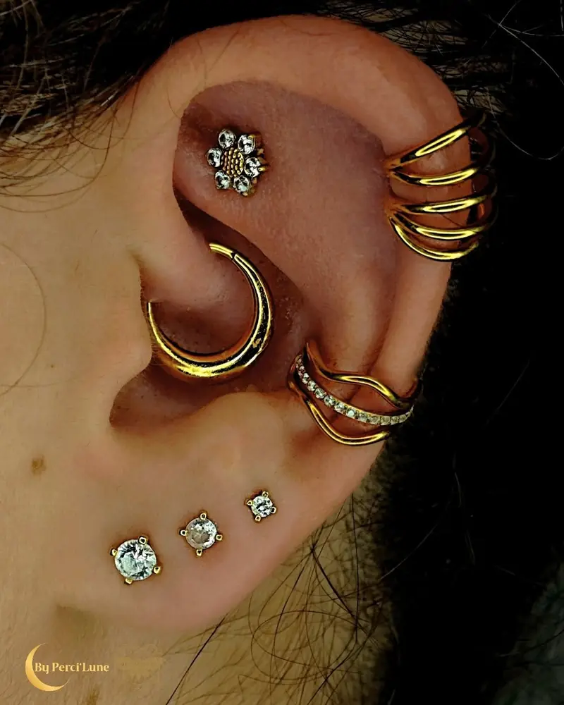 Composition d'oreille dorée : lobes, daith, flat et hélix par Perci'Lune