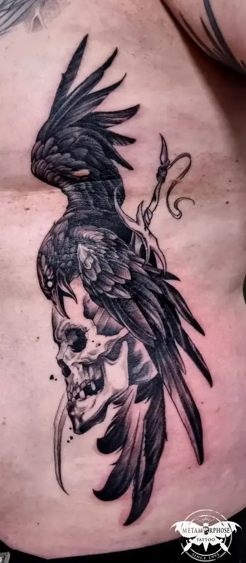 Tatouage corbeau et crâne noir et gris sur les côtes par Mich