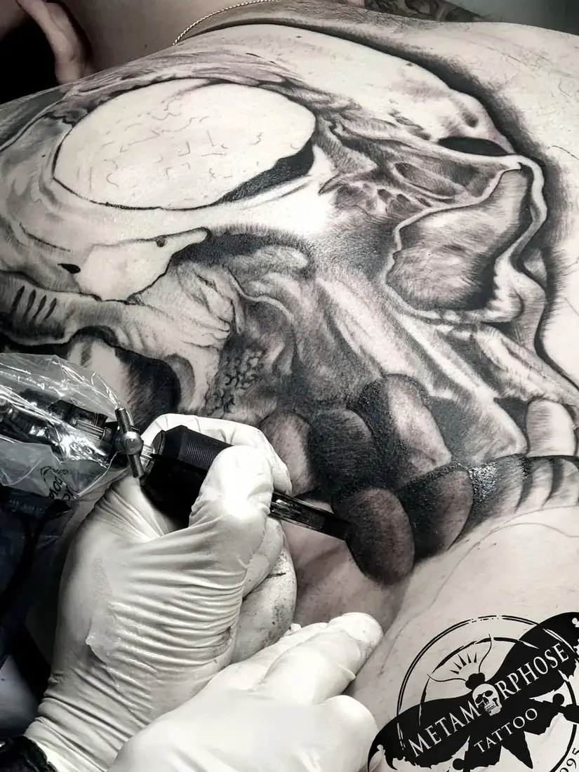Tatouage crâne réaliste noir et gris dans le dos, en cours de réalisation par Mich