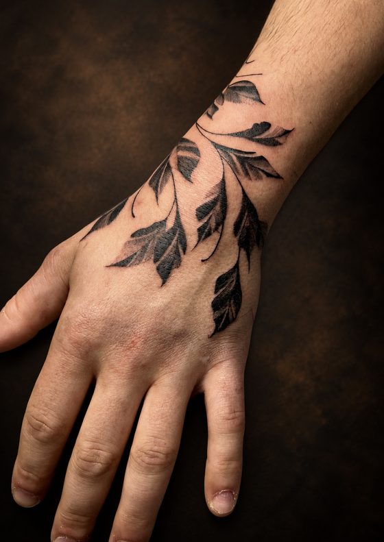 Tatouage feuillage sur la main et le poignet
