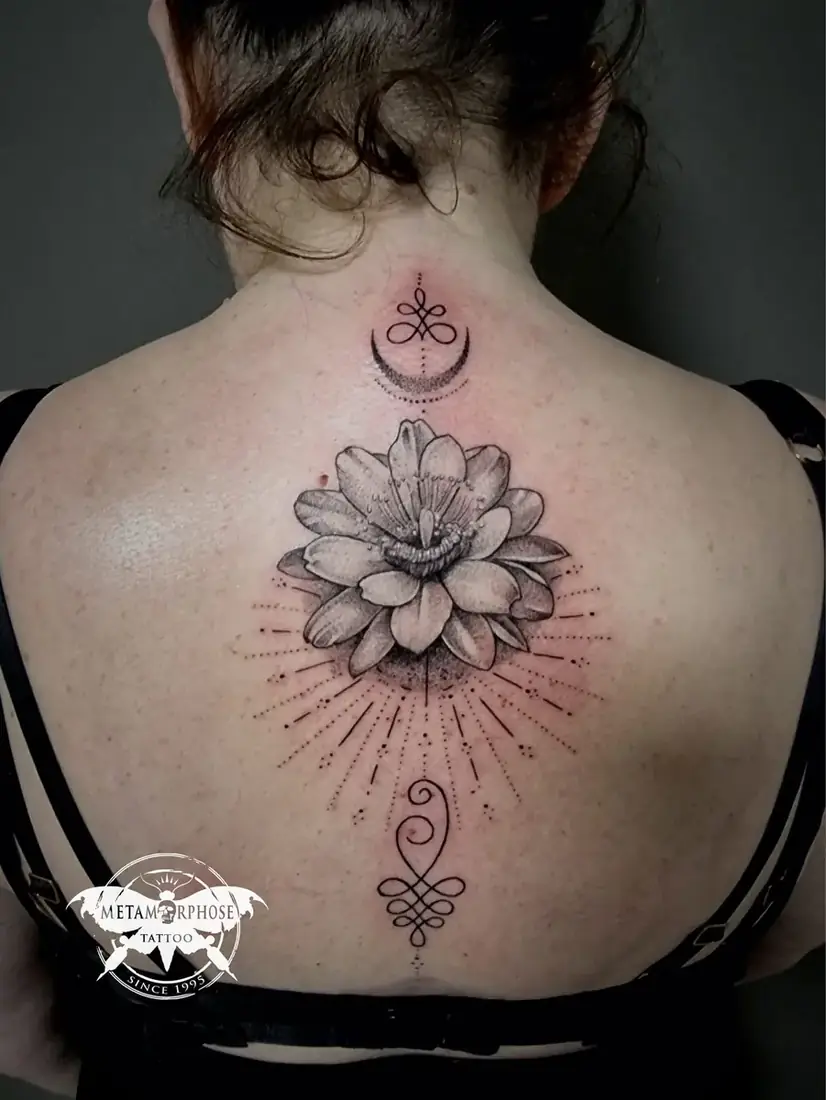 Tatouage fleur de lotus, lune et unalome le long de la colonne par Mich