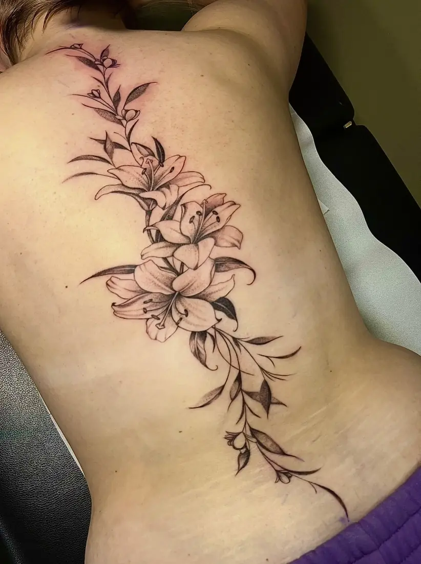 Tatouage fleurs de lys sur le dos par Flo