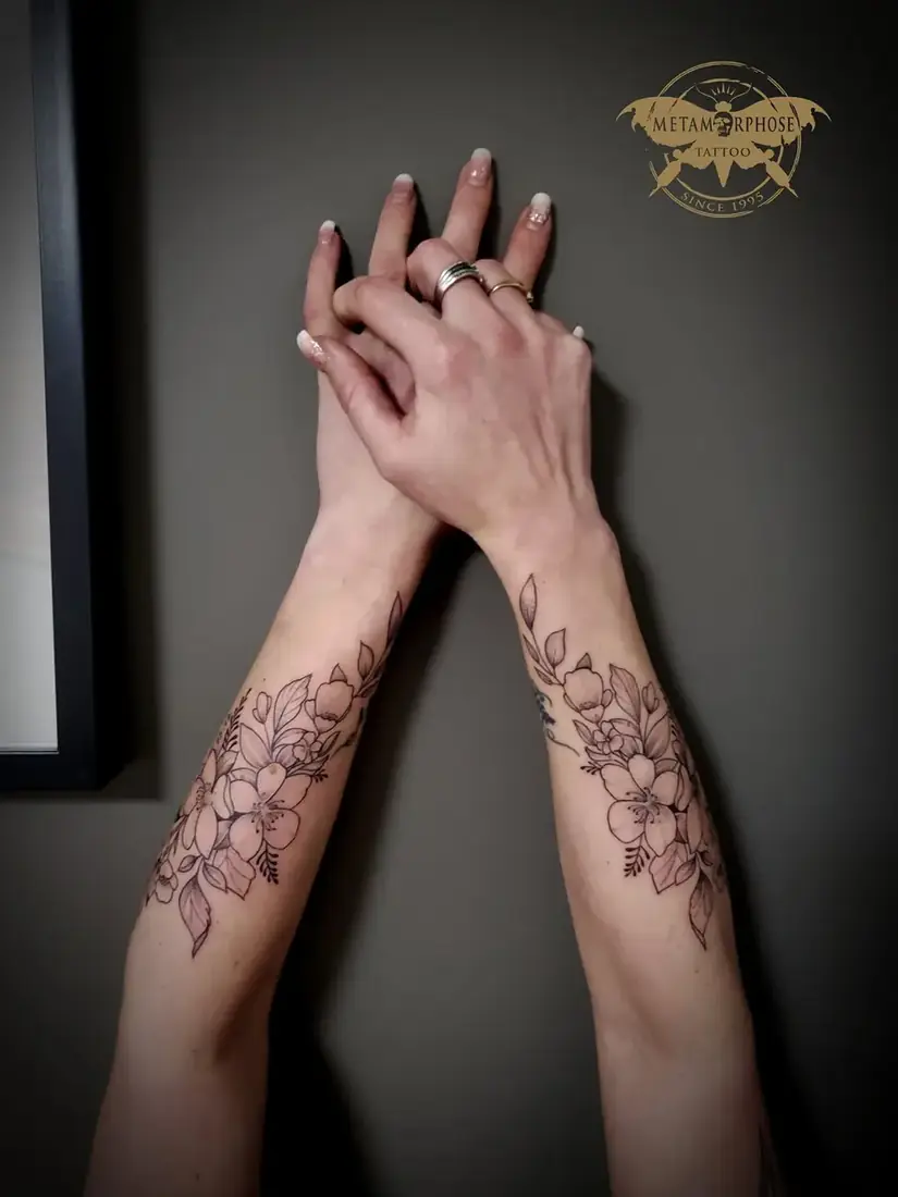 Tatouages fleurs fine line assorties sur les avant-bras par Mich