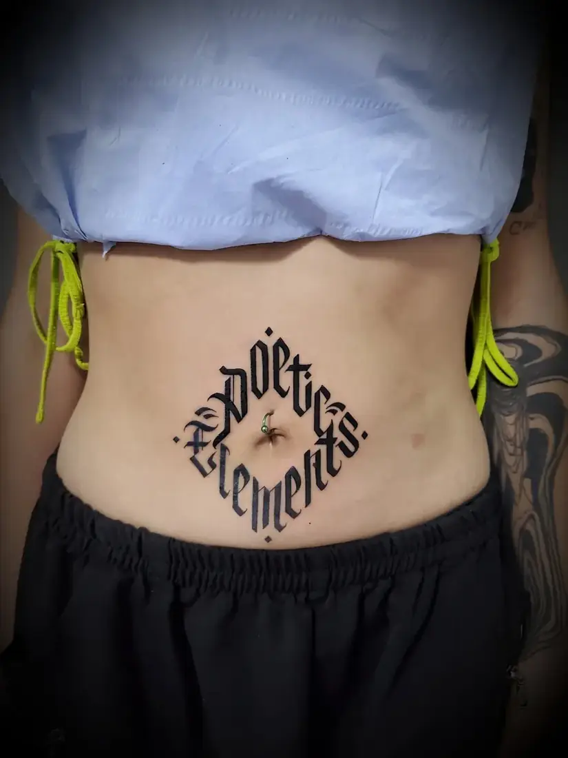Tatouage lettrage gothique ambigramme sur le ventre par Mich