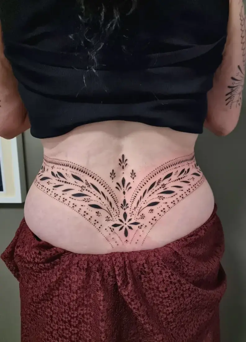 Tatouage ornemental dotwork sur le bas du dos par Mich