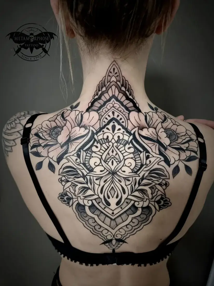 Tatouage ornemental et fleurs sur le haut du dos et la nuque par Mich
