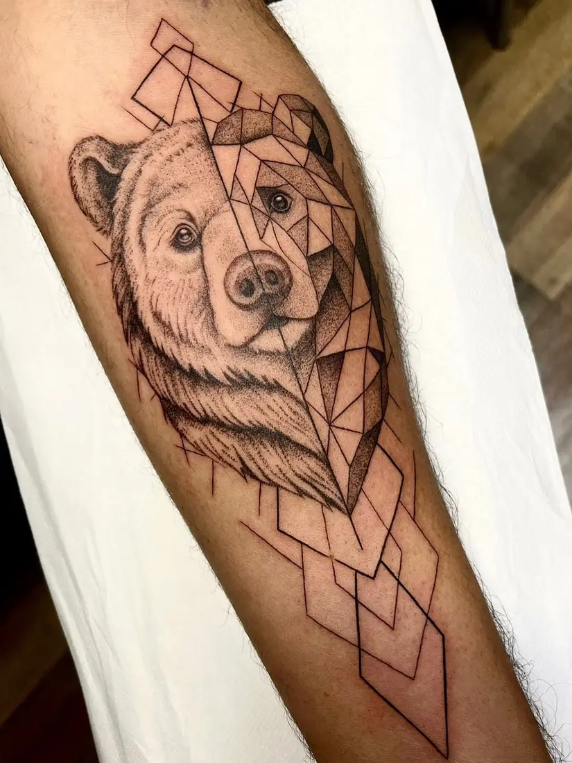 Tatouage ours mi-réaliste mi-géométrique sur l'avant-bras par Flo