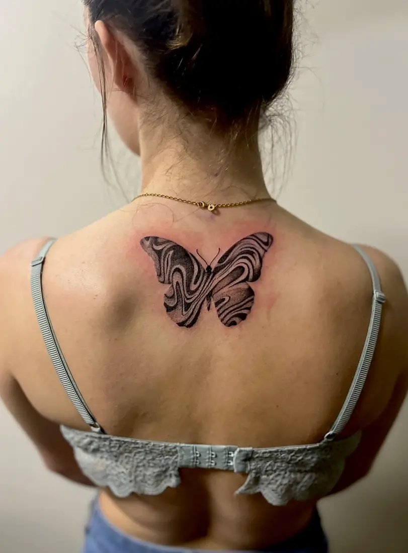 Tatouage papillon marbré sur le dos par Flo