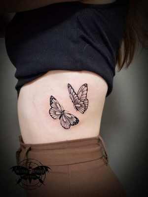 Tatouages papillons noir et gris sur les côtes par Mich