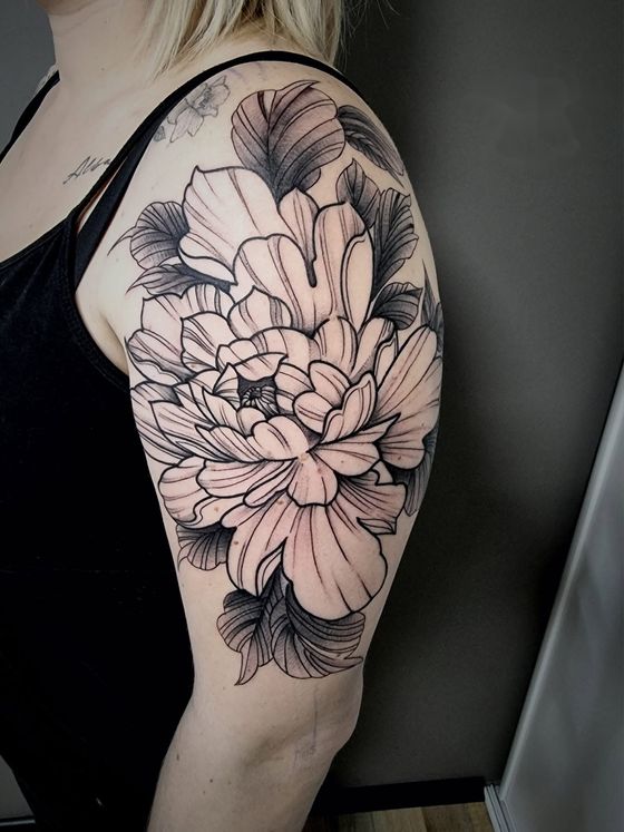 Tatouage pivoine noir et gris sur l'épaule