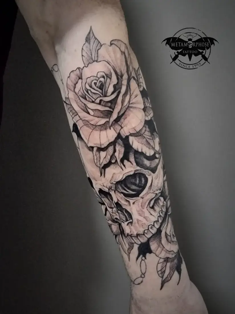 Tatouage rose et crâne noir et gris sur l'avant-bras par Mich