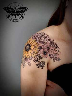 Tatouage tournesol et fleurs sur l'épaule avec prénoms par Mich